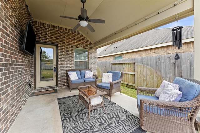 view of patio / terrace with an outdoor living space with a fire pit, fence, and a ceiling fan