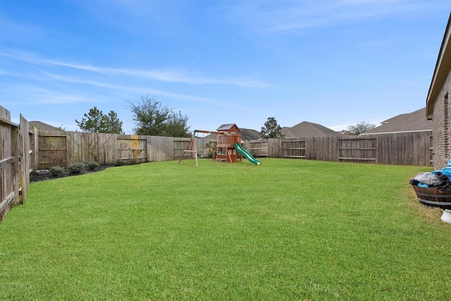 view of yard with a playground and a fenced backyard