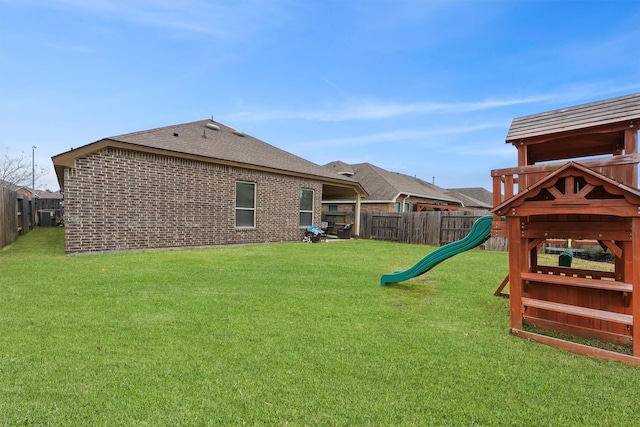 view of yard featuring a playground and a fenced backyard