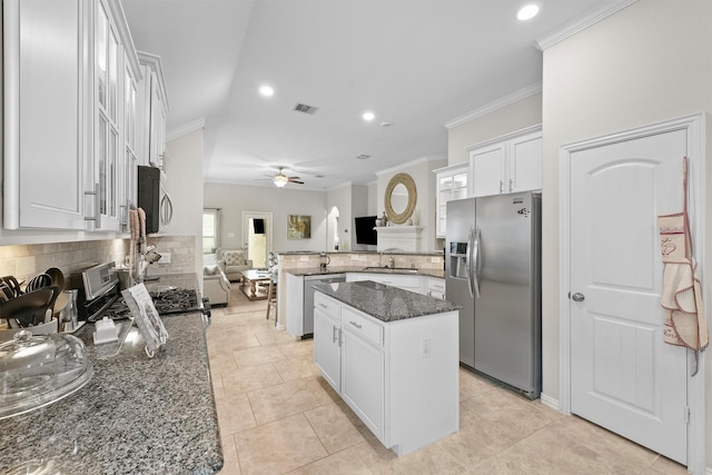 kitchen with a center island, appliances with stainless steel finishes, open floor plan, white cabinets, and dark stone counters