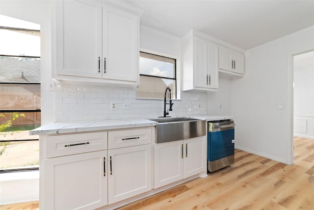 kitchen featuring light hardwood / wood-style flooring, sink, light stone counters, dishwasher, and white cabinets