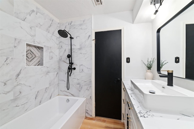 bathroom with vanity, hardwood / wood-style floors, and tiled shower / bath