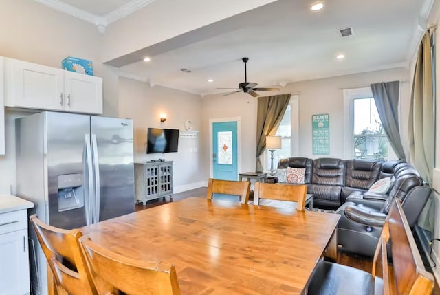 dining space with ceiling fan and crown molding