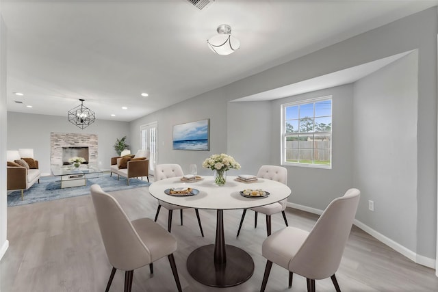 dining room featuring light wood-type flooring and an inviting chandelier