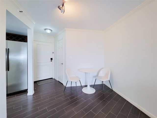 unfurnished room with dark wood-style floors, ornamental molding, and baseboards