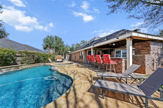 view of pool with pool water feature, a patio, an in ground hot tub, and exterior bar