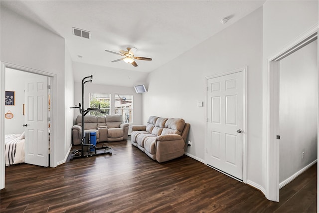 living room featuring ceiling fan, vaulted ceiling, and dark wood-type flooring