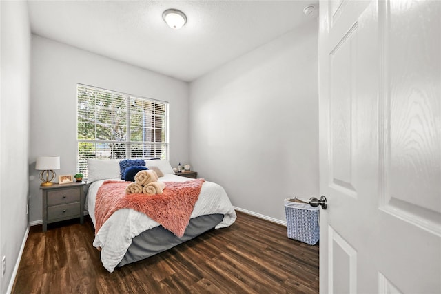 bedroom with dark hardwood / wood-style floors