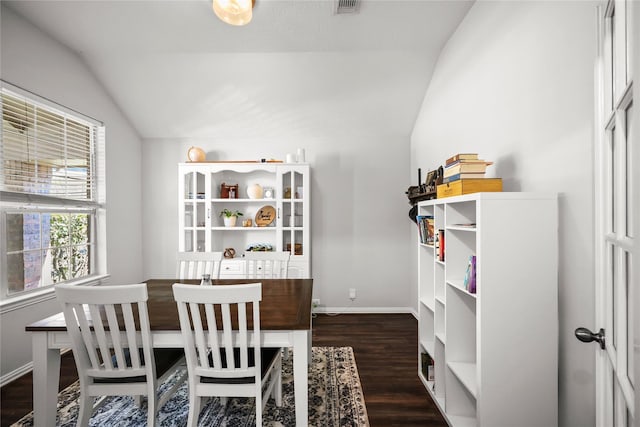 dining room with dark hardwood / wood-style flooring and lofted ceiling