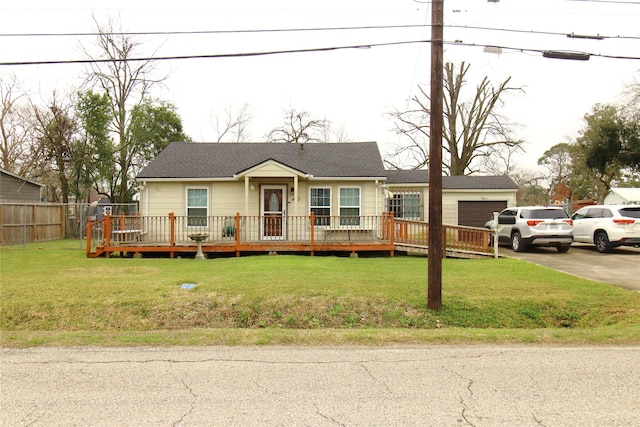 view of front of property with a wooden deck, driveway, a front yard, and fence