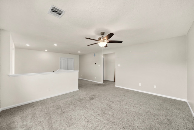 carpeted spare room featuring a textured ceiling and ceiling fan