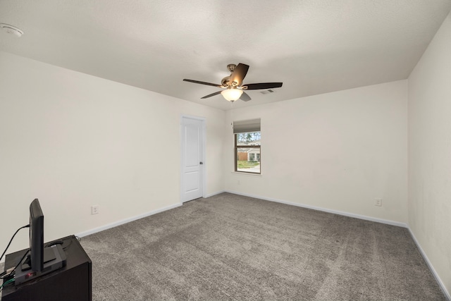 empty room with ceiling fan, carpet floors, and a textured ceiling