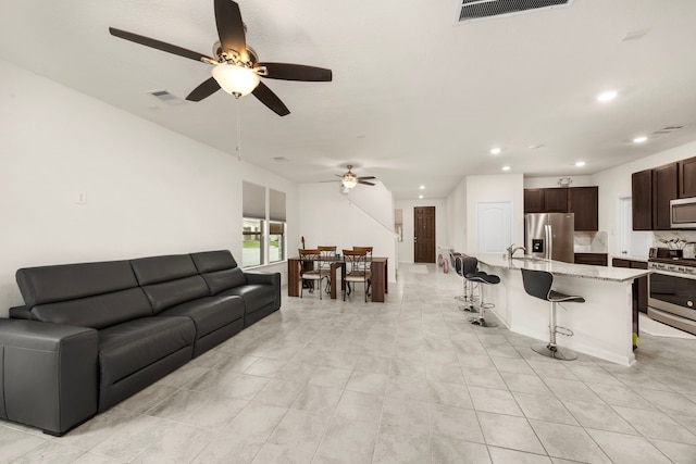 living room featuring ceiling fan and sink