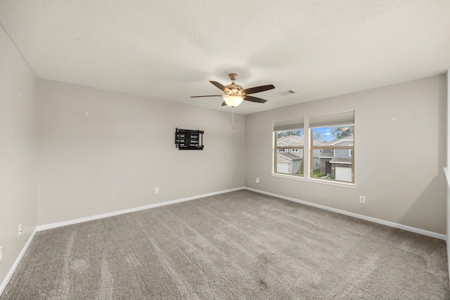 spare room with a textured ceiling, carpet flooring, and ceiling fan