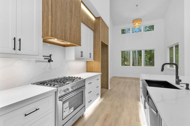 19918 Live Oak Bnd, Magnolia, TX 77355 - kitchen with a sink, backsplash, white cabinets, and appliances with stainless steel finishes