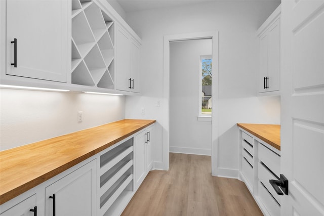 19918 Live Oak Bnd, Magnolia, TX 77355 - kitchen featuring butcher block countertops, white cabinetry, open shelves, and light wood-style floors
