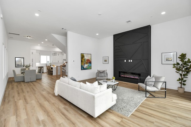 living room with light wood-type flooring and a fireplace