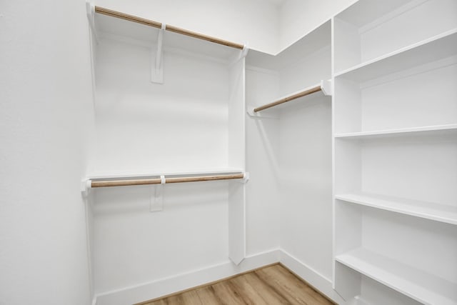 walk in closet with hardwood / wood-style floors