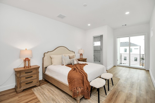 bedroom featuring light hardwood / wood-style flooring, connected bathroom, and access to exterior