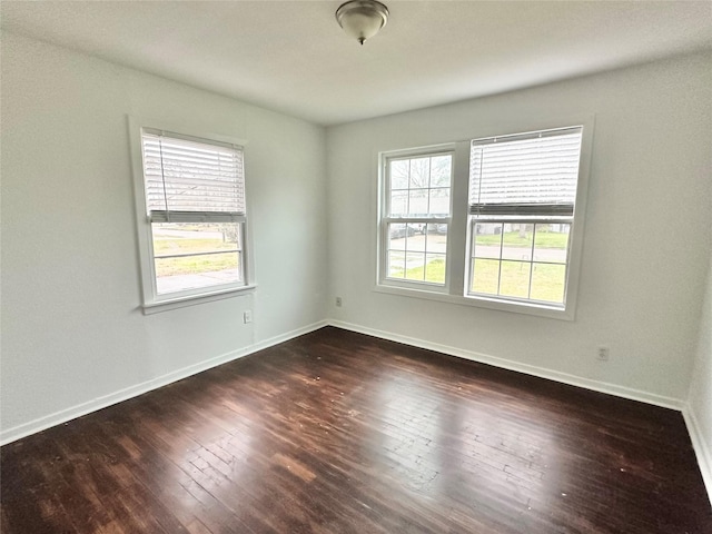 unfurnished room with dark wood-type flooring and plenty of natural light