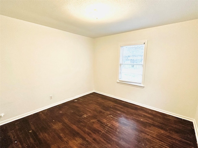 empty room featuring a textured ceiling and hardwood / wood-style floors