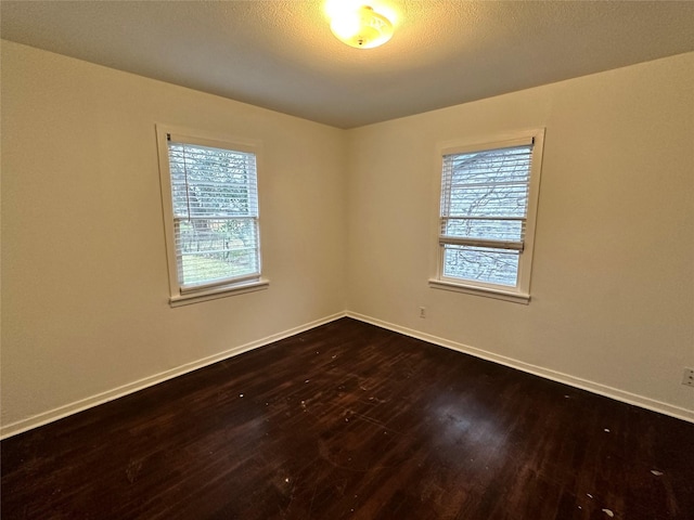 unfurnished room with dark hardwood / wood-style flooring