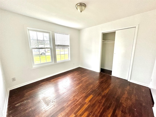 unfurnished bedroom featuring dark hardwood / wood-style flooring and a closet