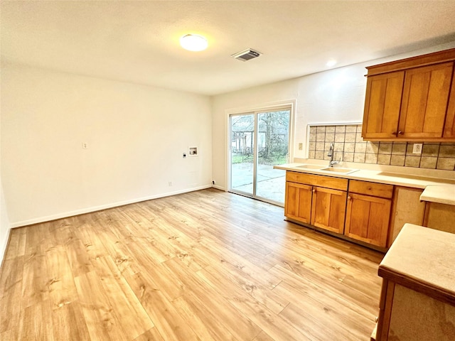 kitchen featuring decorative backsplash, sink, and light hardwood / wood-style flooring