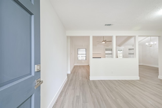 interior space featuring light wood-type flooring, visible vents, and baseboards