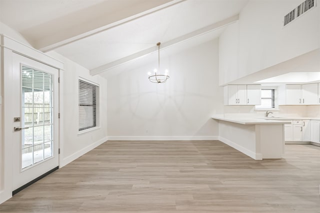 unfurnished dining area featuring beam ceiling, visible vents, light wood finished floors, and baseboards