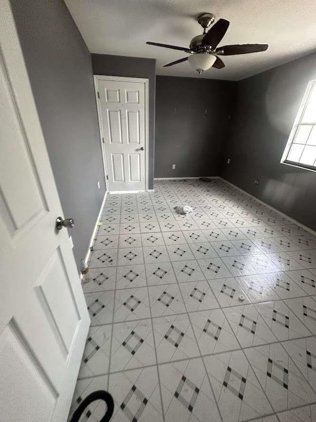 unfurnished bedroom with ceiling fan and a textured ceiling