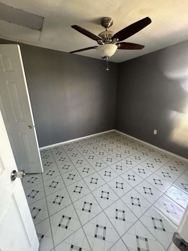 empty room with ceiling fan and a textured ceiling