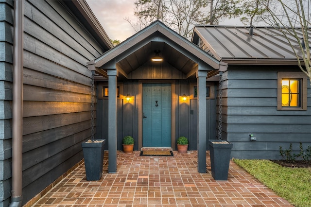 property entrance with metal roof and a standing seam roof