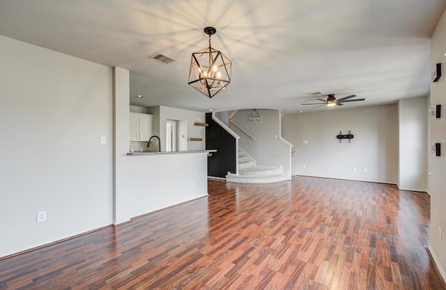 unfurnished living room featuring dark wood-type flooring and ceiling fan