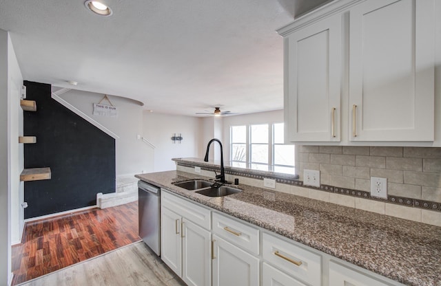 kitchen with light hardwood / wood-style flooring, sink, stainless steel dishwasher, white cabinets, and stone countertops