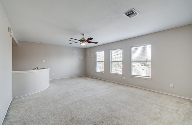 spare room featuring light carpet and ceiling fan