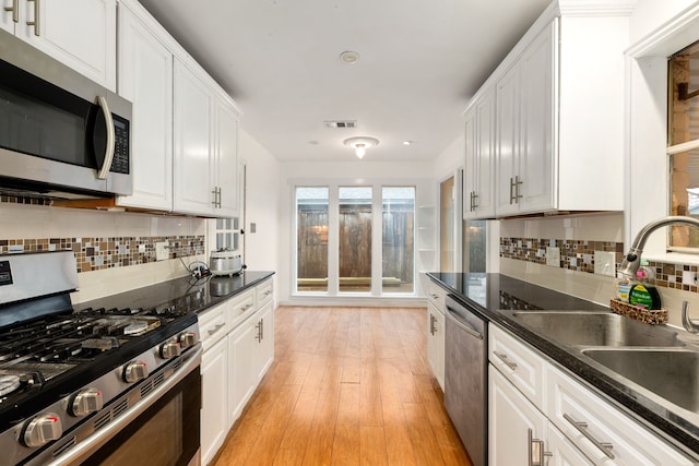 kitchen featuring sink, white cabinets, stainless steel appliances, and light hardwood / wood-style floors