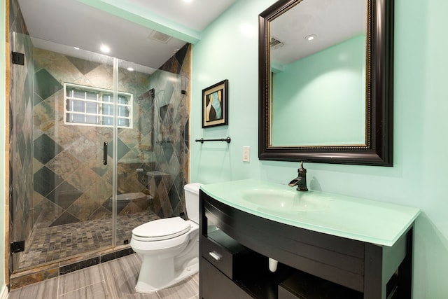 bathroom with toilet, vanity, and an enclosed shower