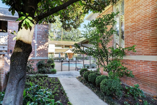 surrounding community with a patio area, fence, and a pool