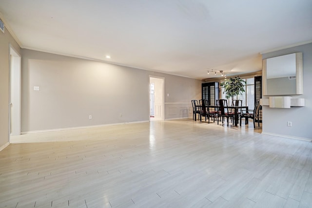 interior space featuring light wood finished floors, baseboards, ornamental molding, and track lighting