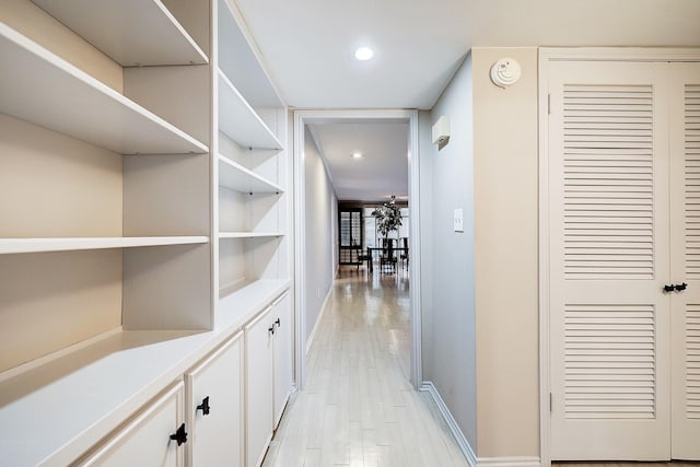 hall with recessed lighting, light wood-type flooring, and baseboards