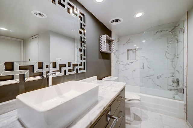 bathroom with visible vents, toilet, vanity, and combined bath / shower with glass door