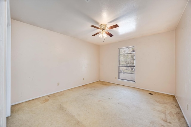 empty room with light carpet, baseboards, and a ceiling fan