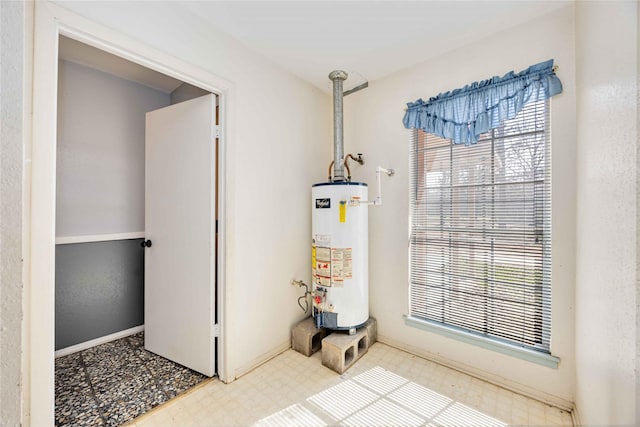 interior space with water heater, baseboards, and tile patterned floors