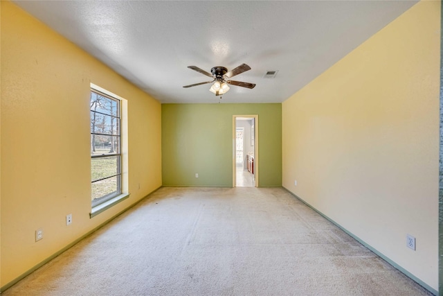 unfurnished room with light carpet, ceiling fan, and visible vents