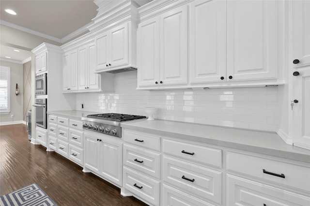 kitchen with light countertops, stainless steel appliances, white cabinetry, and crown molding