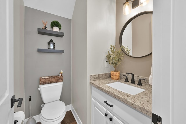 bathroom featuring baseboards, vanity, and toilet