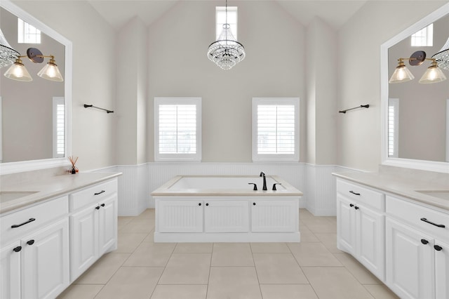 bathroom featuring a wainscoted wall, tile patterned flooring, and a healthy amount of sunlight