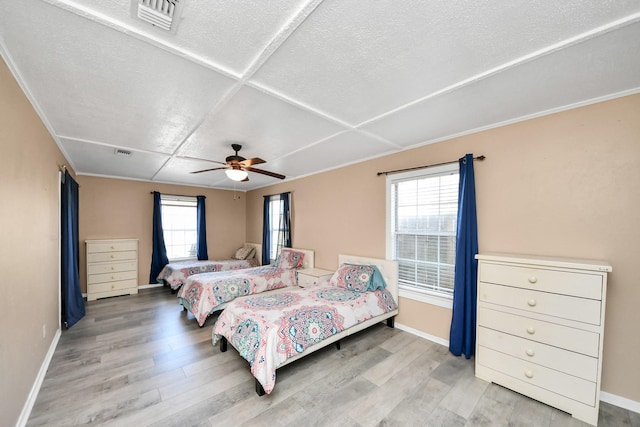 bedroom with visible vents, baseboards, a ceiling fan, and wood finished floors