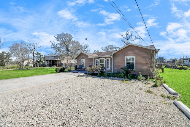 single story home with concrete driveway and a front yard